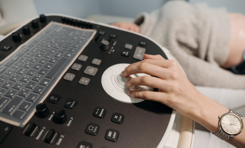 Person in White Long Sleeve Shirt Holding Black and White Braille Machine