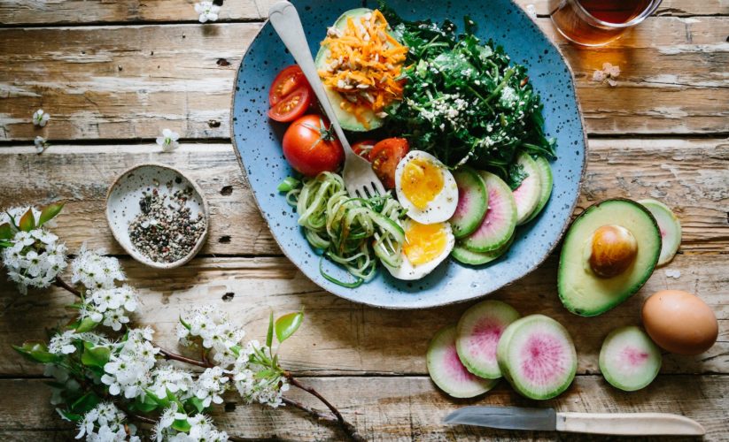 poached egg with vegetables and tomatoes on blue plate